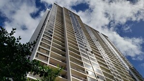 Un immeuble moderne et imposant, doté de nombreux balcons et de grandes fenêtres.