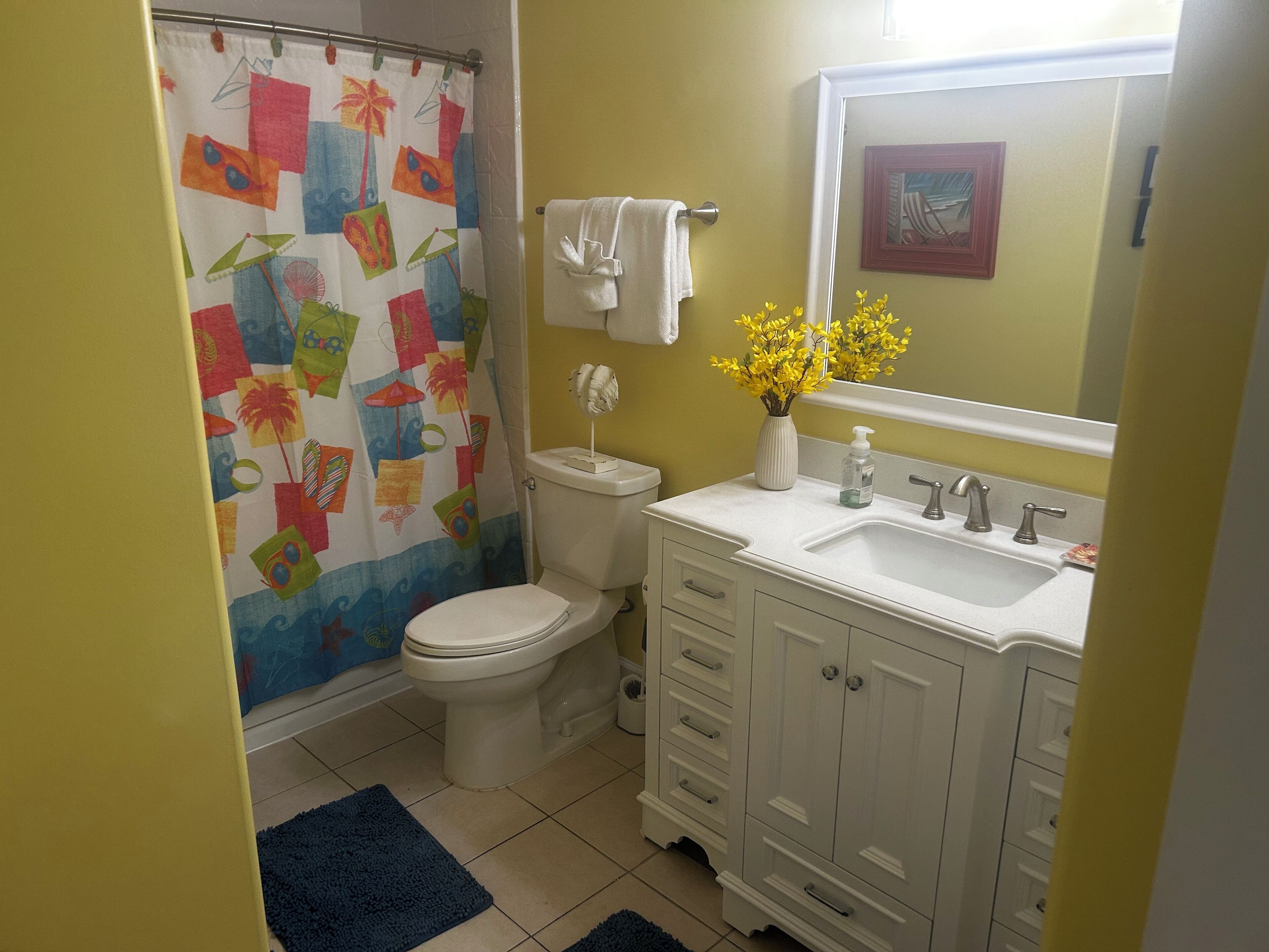 A bathroom with a toilet, sink, and shower curtain.