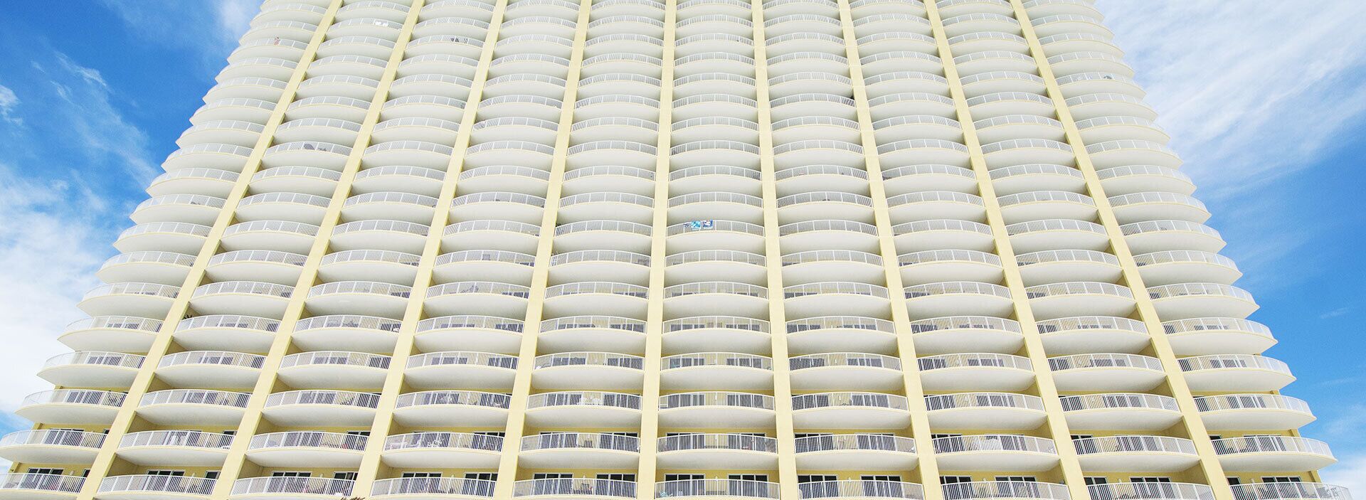 A high-rise hotel with multiple balconies and a clear sky.