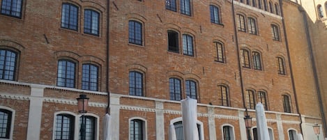 A historic building with a clock tower, multiple windows, and outdoor seating area.