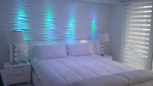Ein Schlafzimmer mit einem Bett, Nachttischen und einer Wand mit strukturierter Oberfläche.
