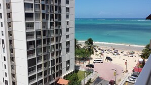Ein Hotel mit hohen Etagen und Balkonen mit Blick auf einen Strand.
