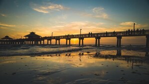 Un muelle que se adentra en el agua, con gente caminando a lo largo.