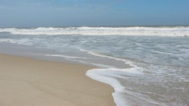 Una spiaggia con le onde che si infrangono sulla riva.