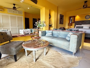 A living room with a sofa, armchair, coffee table, and a rug.
