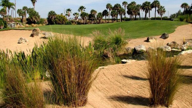 A golf course with sand bunkers, palm trees, and a clear sky. -  3 miles to Disney, Private 4bed/3bath w/ private pool, game room and club house (Kissimmee)