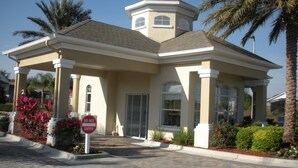 A two-story building with a covered entrance, palm trees, and a 'DO NOT ENTER' sign. -  3 miles to Disney, Private 4bed/3bath w/ private pool, game room and club house (Kissimmee)