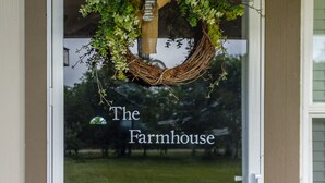 Eine Tür mit einem Kranz und dem Schriftzug "The Farmhouse".