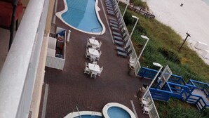 A pool area with a large rectangular pool and a smaller circular pool, surrounded by lounge chairs and tables. - 19th floor with  beach view free beach service and 10% weekly discount (Panama City Beach)