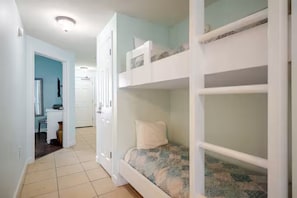 A room with bunk beds, a desk, and a chair. - 19th floor with beach view free beach service and 10% weekly discount (Panama City Beach)