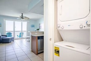 A laundry room with a front-loading washer and dryer, a dishwasher, and a ceiling fan. - 19th floor with beach view free beach service and 10% weekly discount (Panama City Beach)