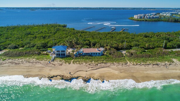 Une propriété située sur la côte, avec une plage, une jetée et un plan d’eau.
