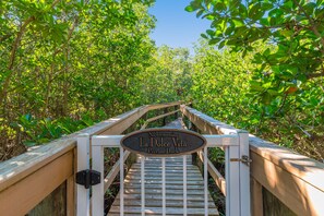 A wooden boardwalk leading to a private dock with a sign reading "No Trespassing La Dolce Vita Private Dock".