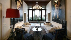 Ein geräumiges Wohnzimmer mit einer großen Sofagarnitur, einem Chandelier und einem großen Fenster mit Blick auf Grünflächen.