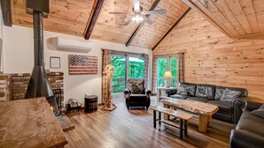 A cozy cabin interior with a fireplace, wooden ceiling, leather sofa, and a dining table. - Camelback,Aquatopia/Camelbeach Waterparks,Pool,Tennis,Jacuzzi,Paintball,Zip-line (Tannersville)