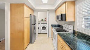 Eine moderne Küche mit eingebautem Backofen, Mikrowelle und einem Edelstahl-Kühlschrank.