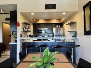 A modern kitchen with a central island, built-in appliances, and a dining area with bar stools. - 7 Mins to Lake Tahoe Beaches, 3 Mins to Heavenly Ski Slopes! Breathtaking Views! (Stateline)
