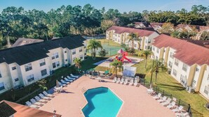 A pool area with lounge chairs and a children's play structure. - Welcome To Potter's Castle! Near Disney, Slps 8, Harry Potter Decor, Pool, WOW! (Kissimmee)