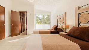 A bedroom with two beds, a wooden wardrobe, a window with a view of greenery, and a wall-mounted lamp. - Luxurious & Comfortable Residence!!! - Hotel Zone - Condo on The Beach (Cancún)