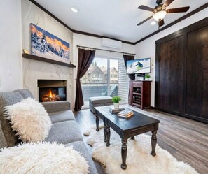 A living room with a fireplace, a sofa, a coffee table, and a television.