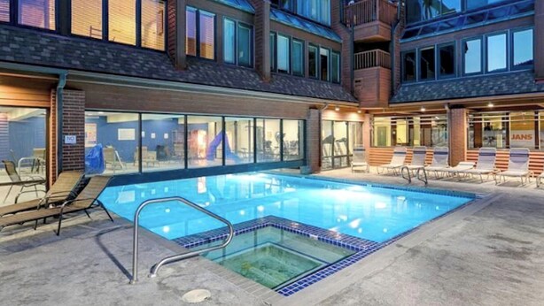 A modern hotel with a swimming pool, outdoor seating, and large windows. - A+ ski-in/out REMODEL NOW 2026 @ PC pool/gym/hot tub/washer/wifi/fireplace (Park City)