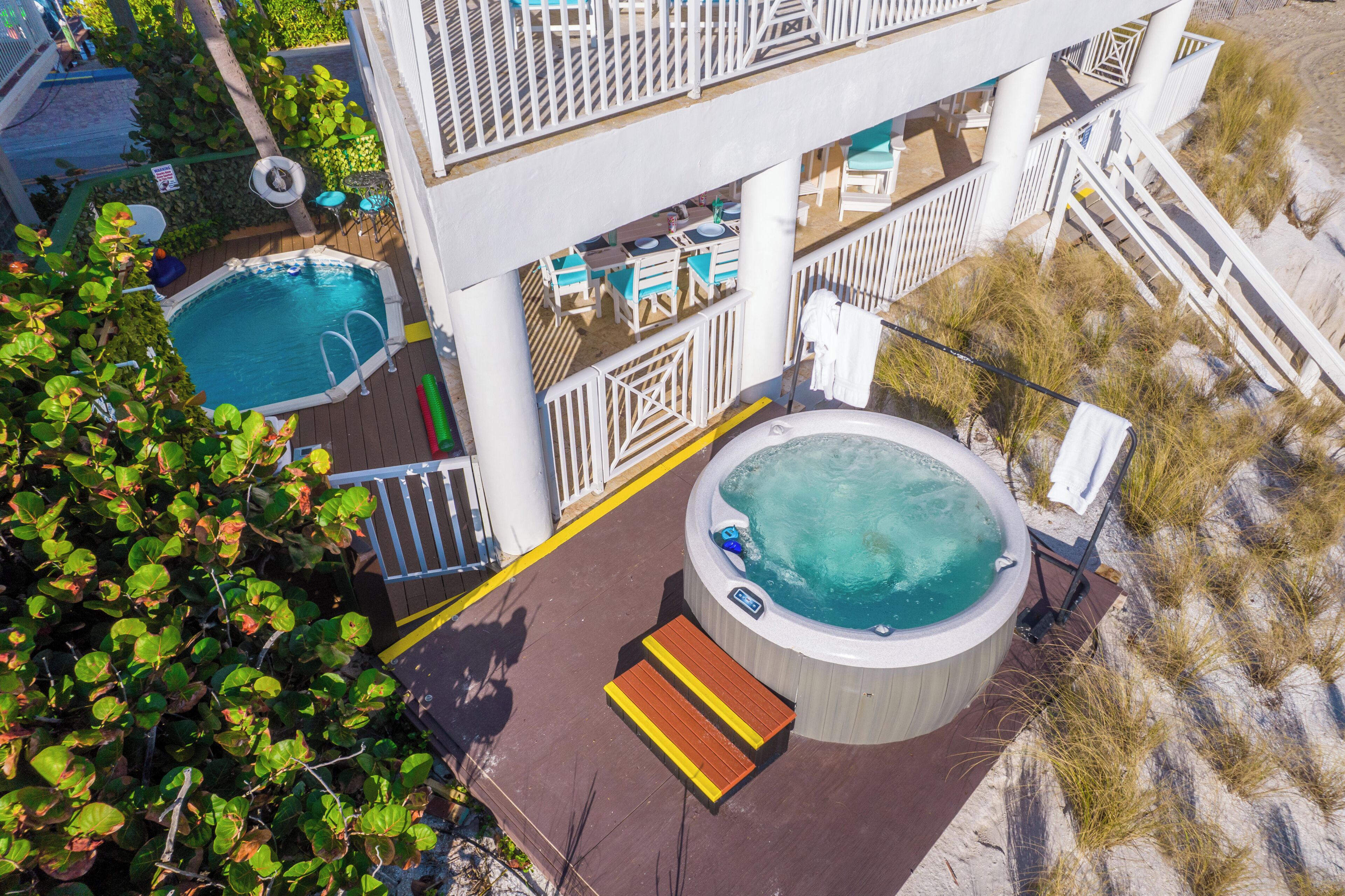 A pool area with a hot tub, lounge chairs, and a deck.