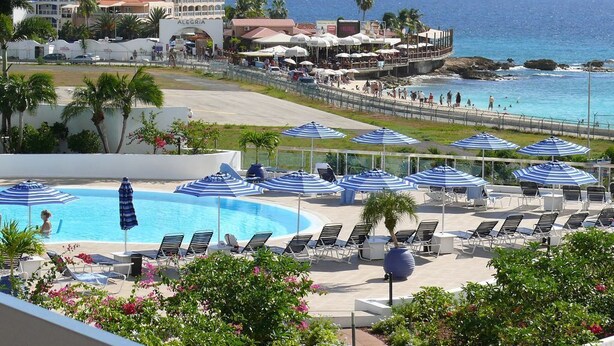 A resort with a pool area, sun loungers, and umbrellas. - Tropical Gem! Watch Jets Fly into Airport+Ocean Beach+Garden Views+MANY PERKS!!! (Maho Bay)
