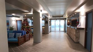 A spacious hallway with a Christmas tree, a reception desk, and a stone wall. - Tropical Gem! Watch Jets Fly into Airport+Ocean Beach+Garden Views+MANY PERKS!!! (Maho Bay)