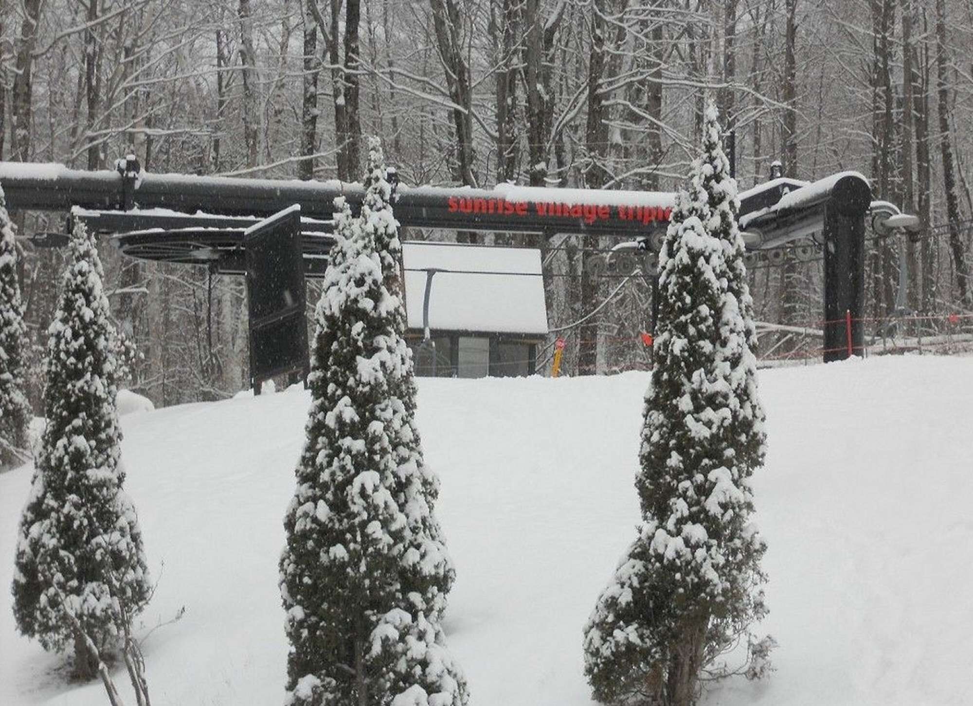 Un paysage enneigé avec un panneau indiquant « Sunrise Village Inn ».