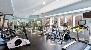 Ein Fitnessstudio mit Laufbändern, Crosstrainern und Krafttrainingsgeräten.