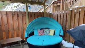 A round, turquoise outdoor seating area with a bench and a trash bin. - Art Studio: Historical Carriage House in the Poconos (Jim Thorpe)