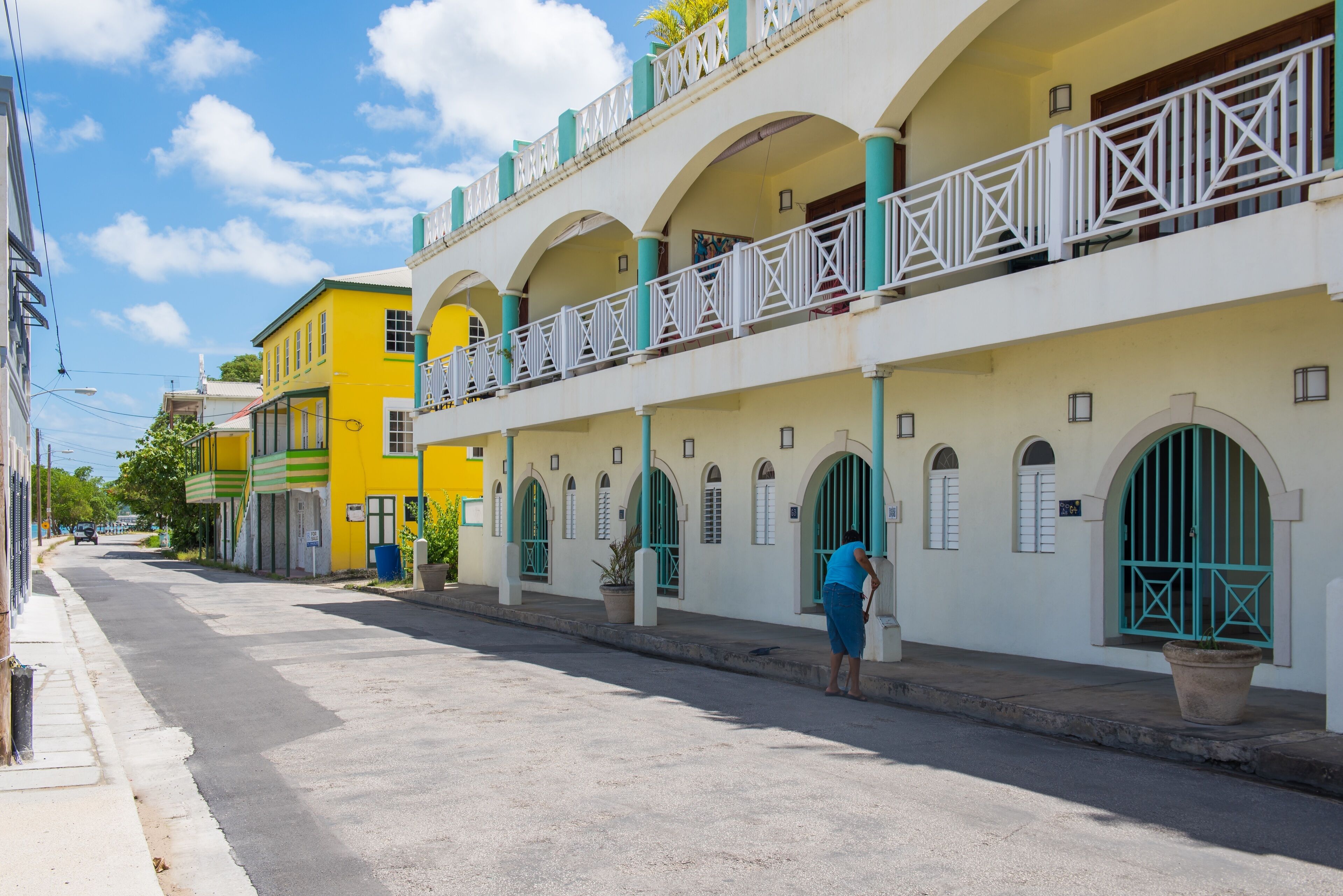 A street with buildings featuring balconies and arched windows.