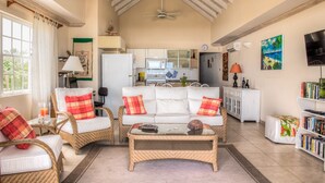 A spacious living area with a high ceiling, a dining area, and a kitchen. - Beachfront penthouse, Speightstown, stunning West Coast, full AC, near amenities (Speightstown,)