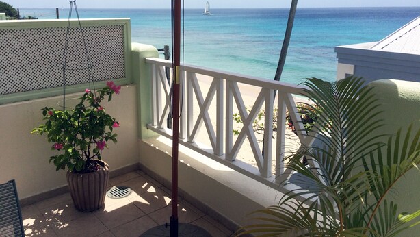 A balcony with a view of the ocean, a potted plant, and a white railing. - Beachfront penthouse, Speightstown, stunning West Coast, full AC, near amenities (Speightstown,)