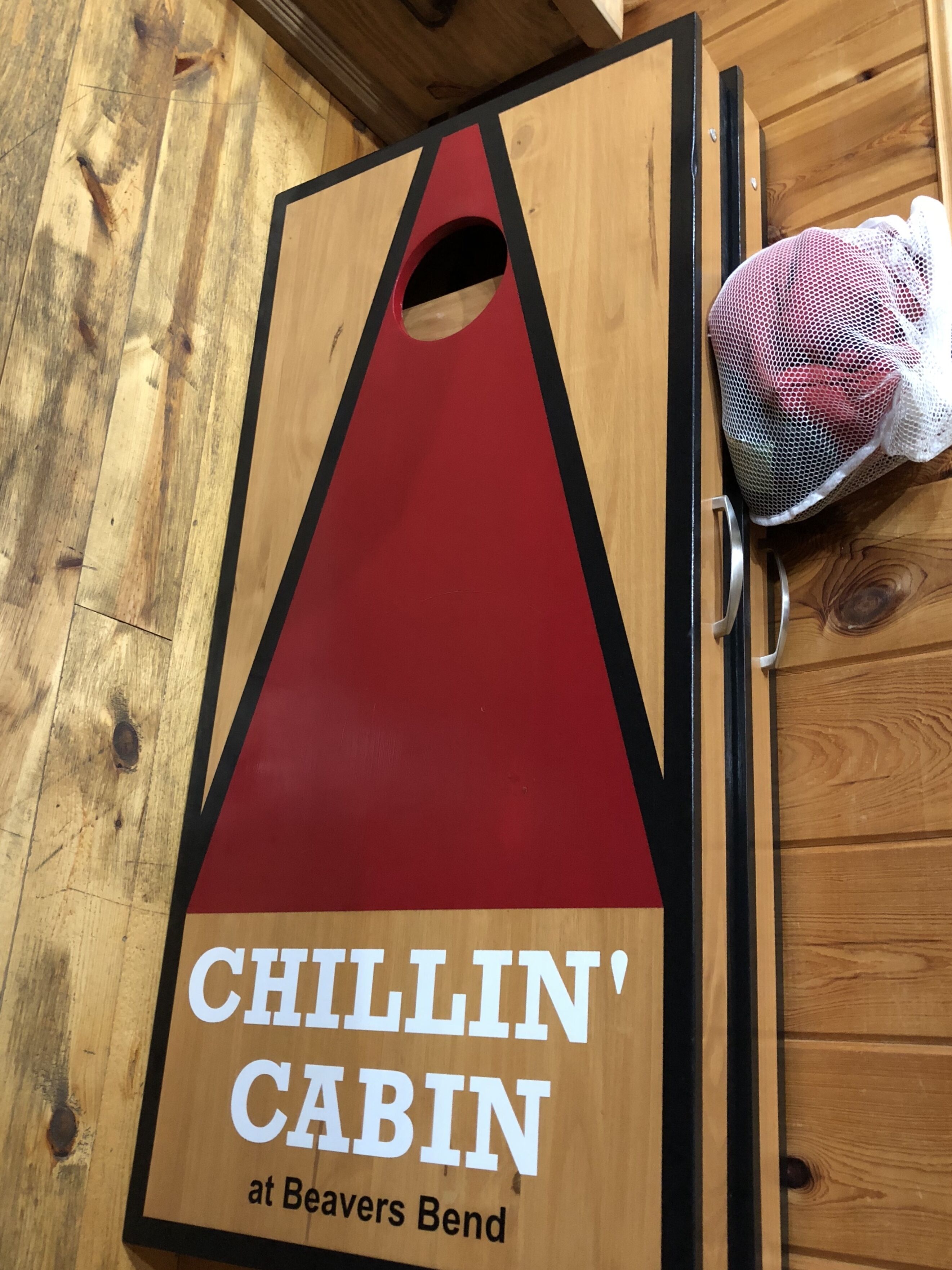 Eine Holztür mit einem roten und schwarzen Schild, auf dem 'CHILLIN' CABIN at Beavers Bend' steht.