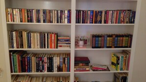 A bookshelf filled with various books, including novels, non-fiction, and reference materials.