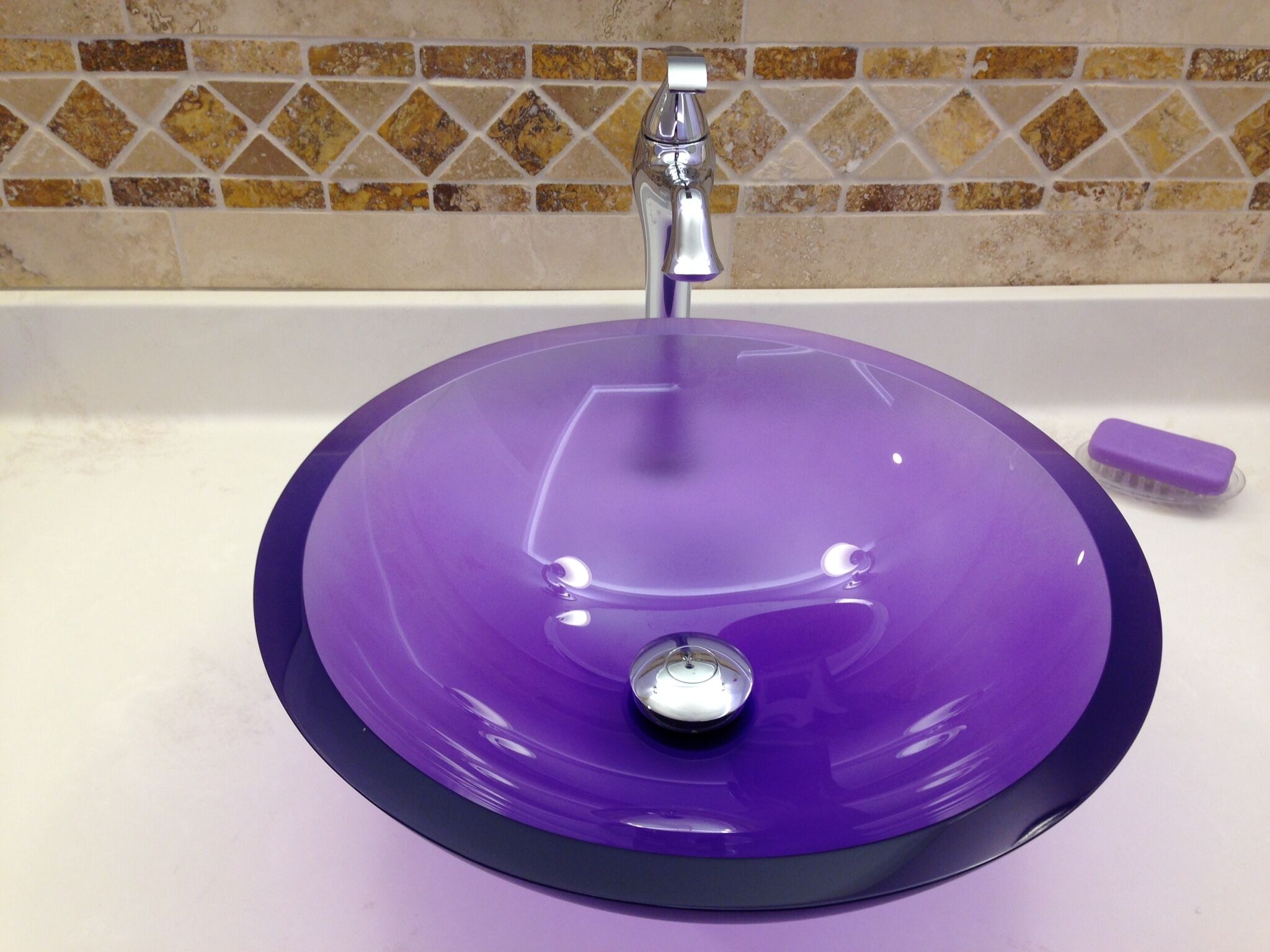 Un lavabo de salle de bain avec un receveur violet et un robinet.