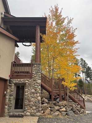 A building with a stone entrance, wooden staircase, and a balcony. - SKI IN OUT Perfect for 9 or 19 guests. Above Breckenridge Ski Base Area 8 (Breckenridge)