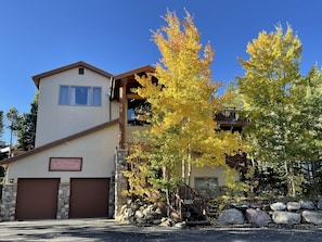 A two-story building with a stone facade, a garage, and a sign indicating a restaurant.