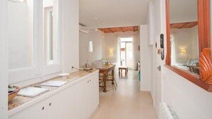 A narrow hallway with a dining area at the end, featuring a table and chairs. - Close Gaudi, Gracia equipped apartment, Barcelona, WIFI, balcony, AC & elevator (Barcelona)
