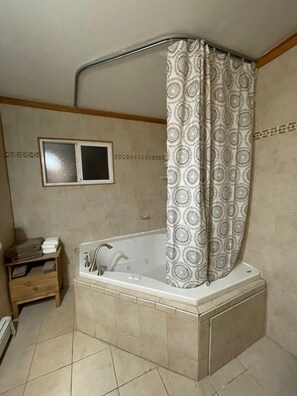 Une salle de bain avec une baignoire sur pieds, un porte-serviettes et une fenêtre.