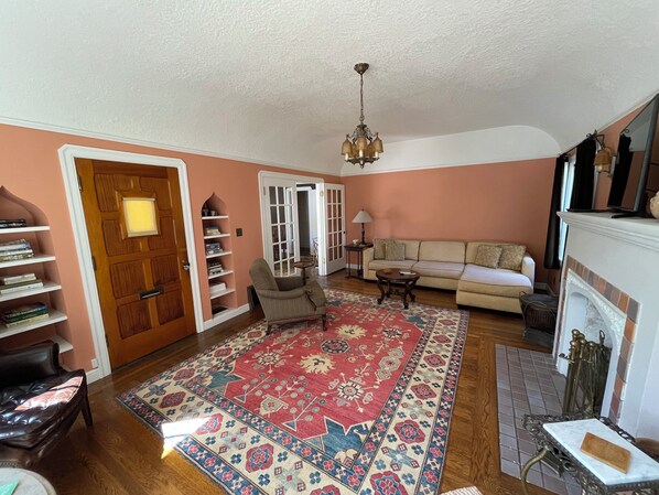 A living room with a sofa, armchair, and a patterned rug. - F.J. Massa House ~ Walk to Downtown Napa ~ Bocce Court (Napa)