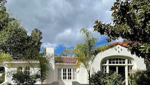 A two-story building with a central entrance, surrounded by well-maintained gardens and a paved walkway.