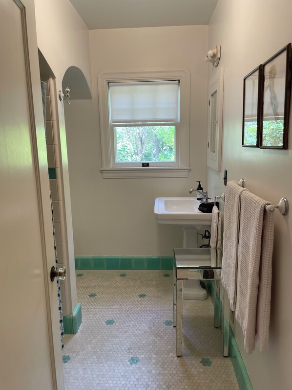 A bathroom with a toilet, sink, and window.