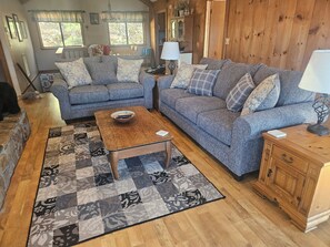 Un salon chaleureux avec un canapé bleu, une table basse en bois et un tapis à motifs.