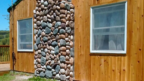 A wooden cabin with a stone wall and two windows. - Mountain Top Retreat, 116 private acres (Hobart)
