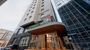 A hotel with a modern design, featuring a prominent sign and a glass facade.