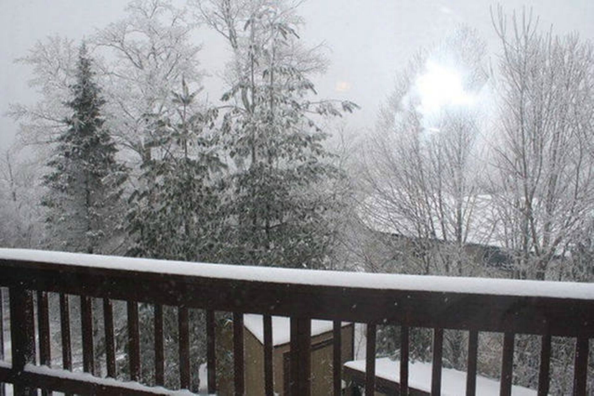 A snow-covered deck with a railing.
