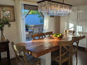 A wooden dining table with a bowl of green apples, surrounded by wooden chairs. - KAYAK-SUP-SWIM--ALL YEAR, Gorgeous  LAKE walks-Just STEPS away & Restaurants (Austin)