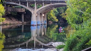 A bridge with graffiti over a calm river, surrounded by greenery. - KAYAK-SUP-SWIM--ALL YEAR, Gorgeous  LAKE walks-Just STEPS away & Restaurants (Austin)